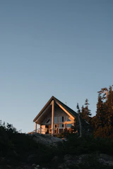 Modern wooden chalet surrounded by greenery with warm lighting