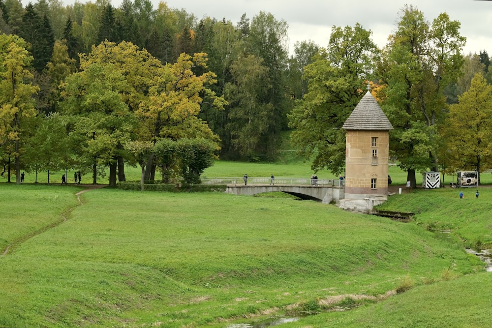 a small building sitting on top of a lush green field