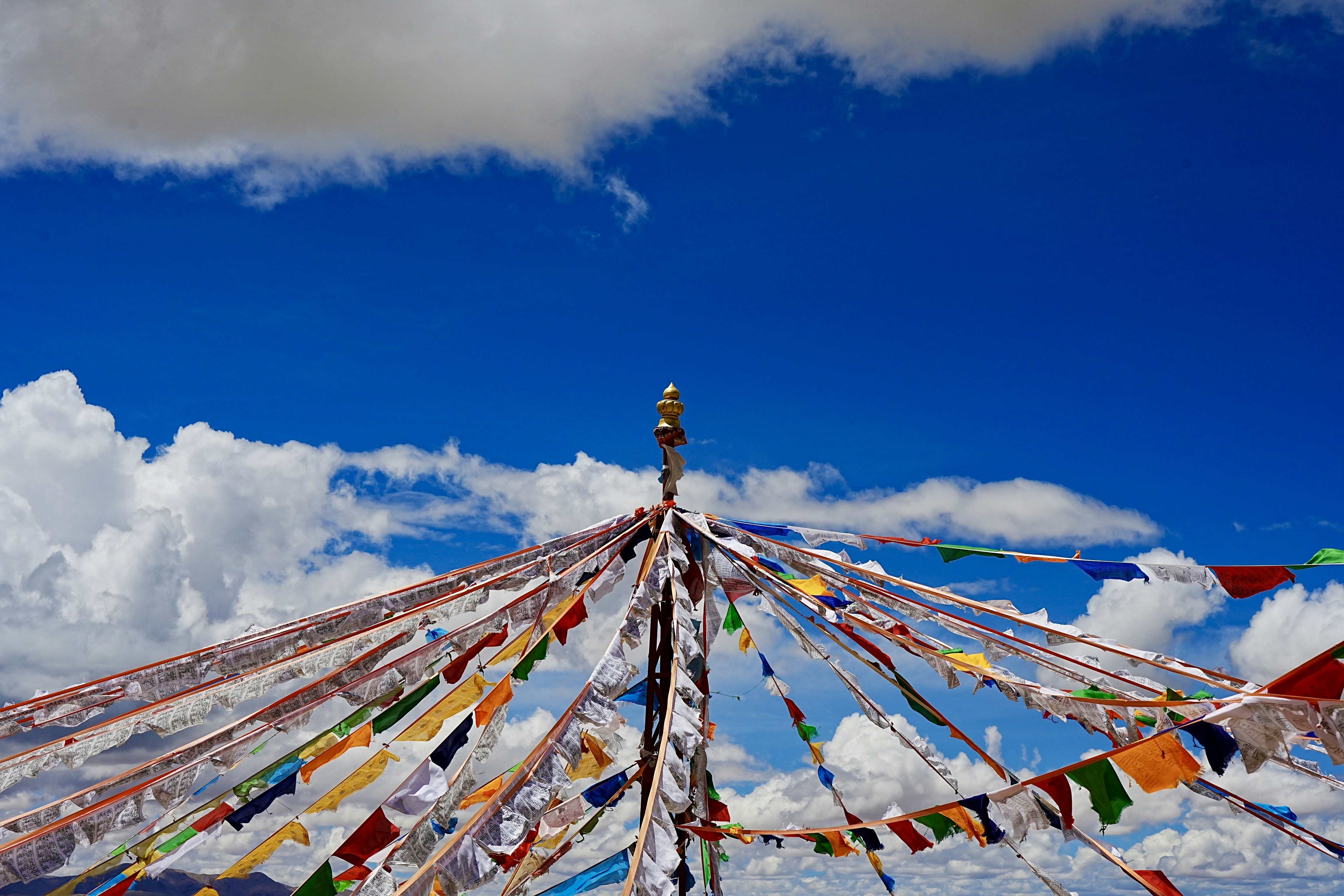 a group of colorful flags hanging from a pole
