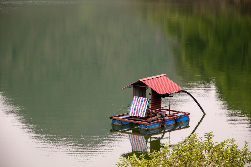 a small house boat floating on top of a lake