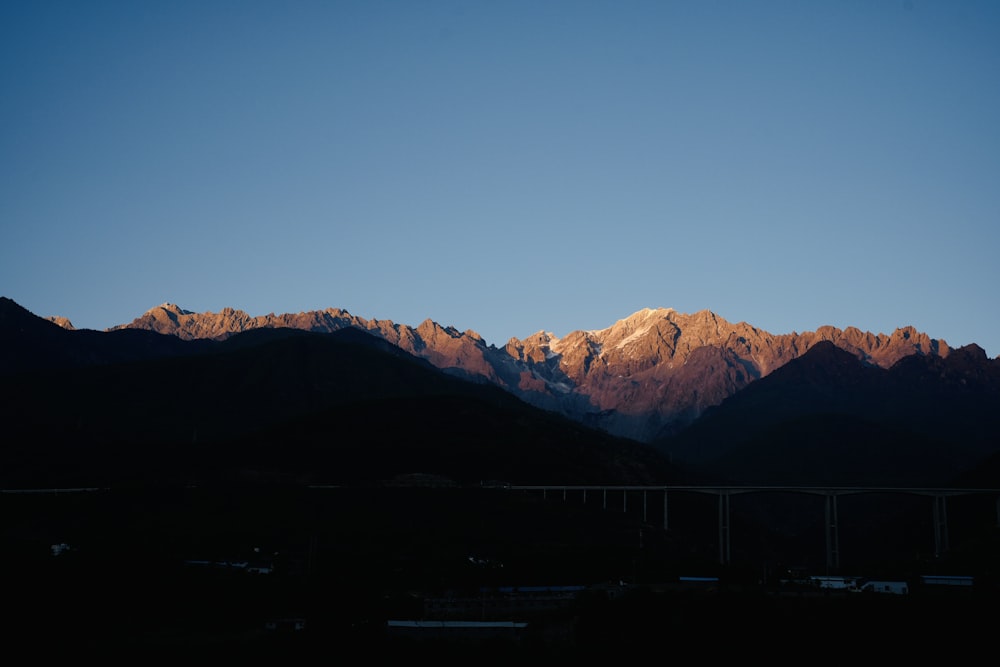 a view of a mountain range with a bridge in the foreground