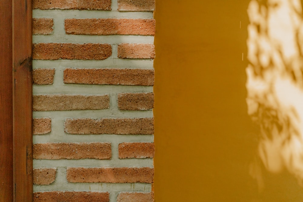 a red fire hydrant sitting next to a yellow wall