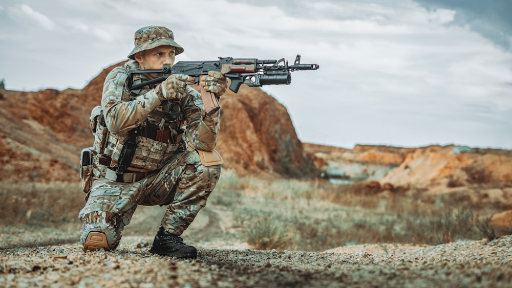 a man in camouflage holding a machine gun