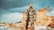 A man in camouflage military gear stands confidently in a rugged, desolate landscape. His attire includes tactical equipment and a rifle slung over his shoulder. The background features dramatic, cloudy skies and rocky, barren terrain with some sparse vegetation.