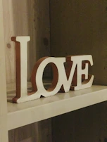 Hand-painted MDF decorative letters spelling a child's name, displayed on a nursery shelf.