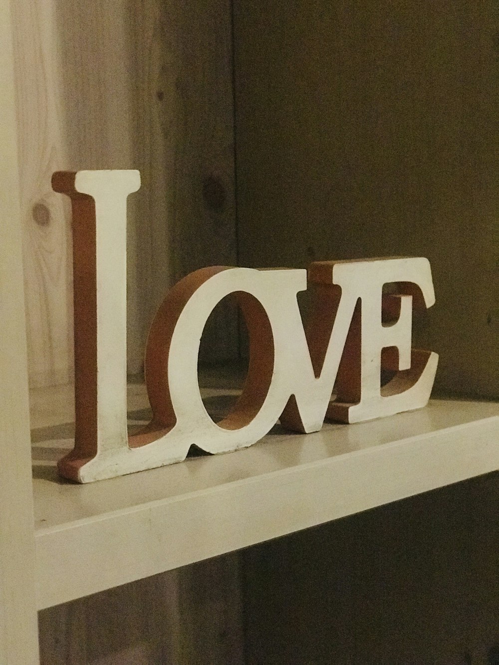 a wooden love sign sitting on top of a shelf