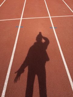A coach giving tactile instructions to a visually impaired athlete on the track.
