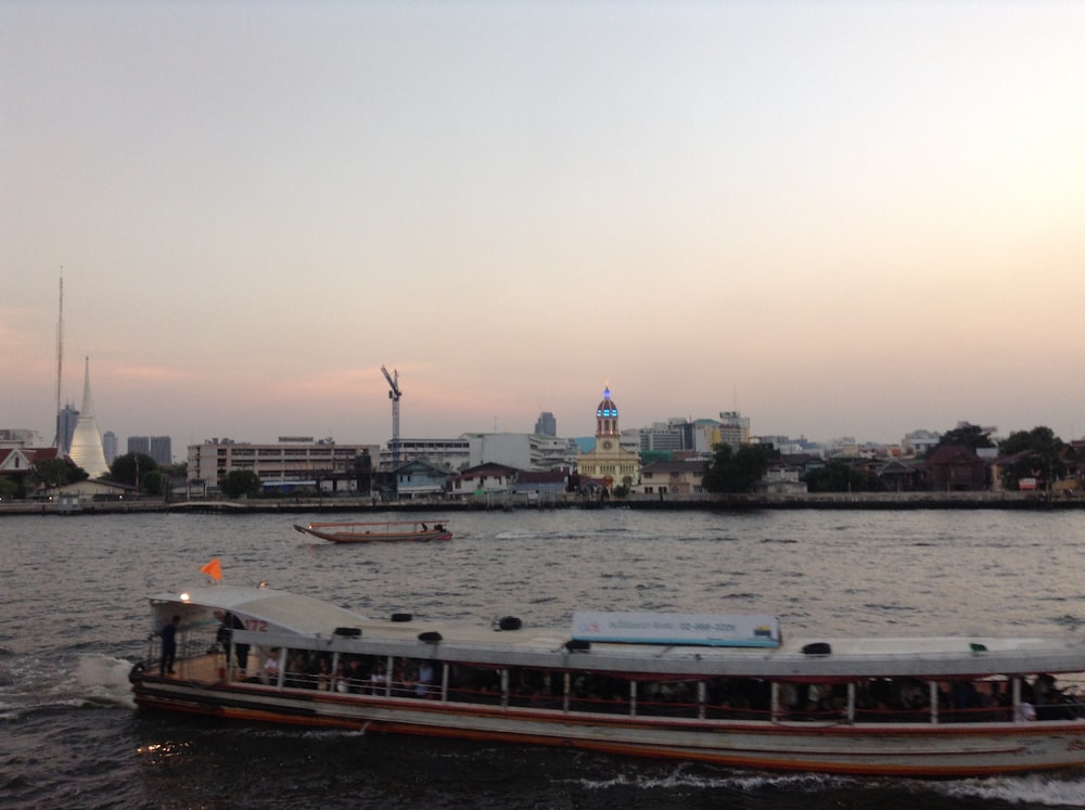 a boat is traveling down the river with a city in the background