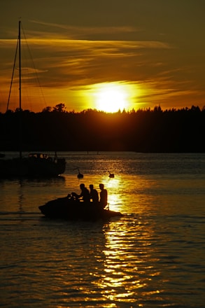 A couple enjoying a private boat ride at sunset with golden skies over the Bay of Bengal.
