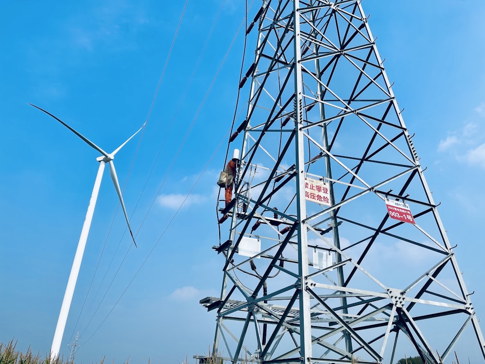 a man on a high voltage power line working on a wind turbine