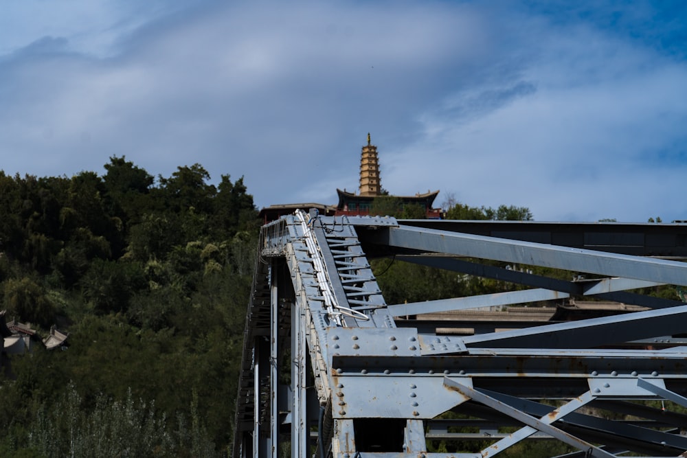 a metal bridge with a tower in the background