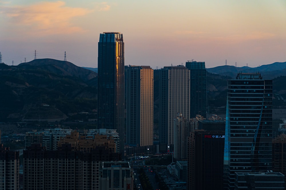 a view of a city at sunset with mountains in the background