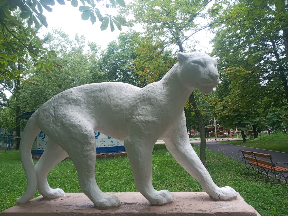 Une statue d’un chat blanc dans un parc