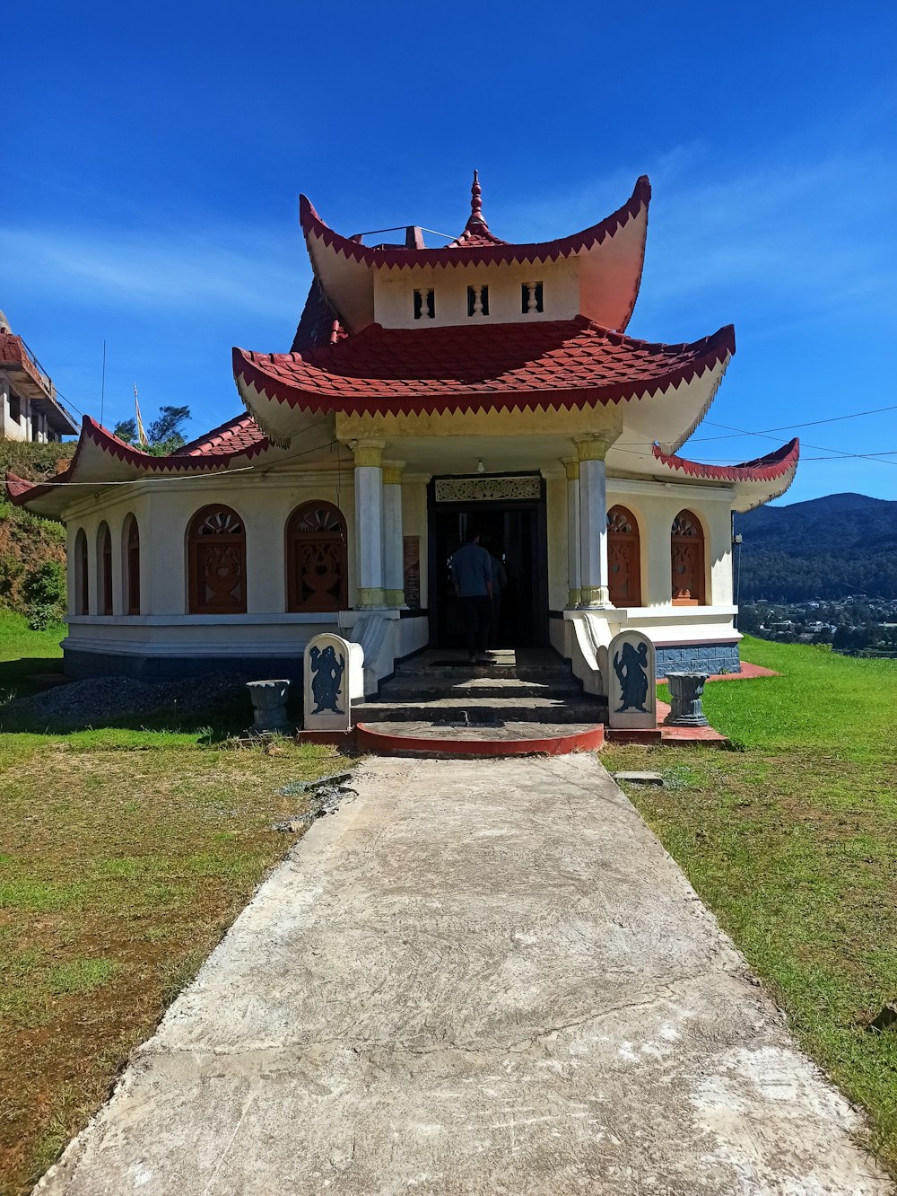 a white and red building sitting on top of a lush green field