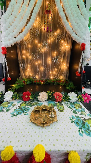 A beautifully decorated wedding mandap with floral arrangements and soft lighting.