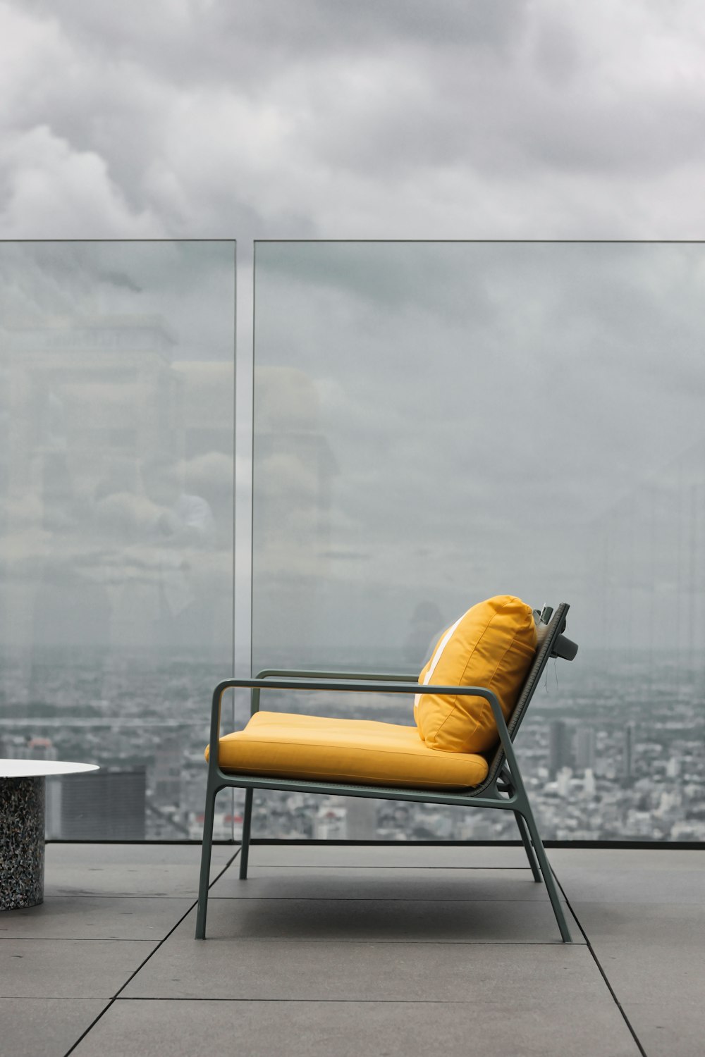 a yellow chair sitting in front of a glass wall