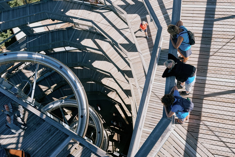 a group of people standing on top of a wooden walkway