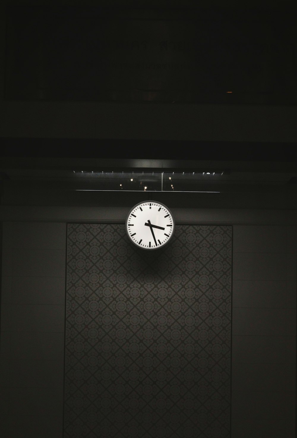 a clock on a wall in a dark room