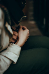 Close-up of hands nervously clasped together, showing inner tension.