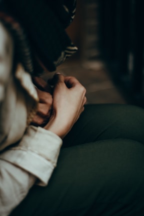 Close-up of a participant’s hands resting gently on their knees during a private mindfulness session