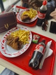 A combo meal featuring fried chicken, fries, and a soft drink on a tray
