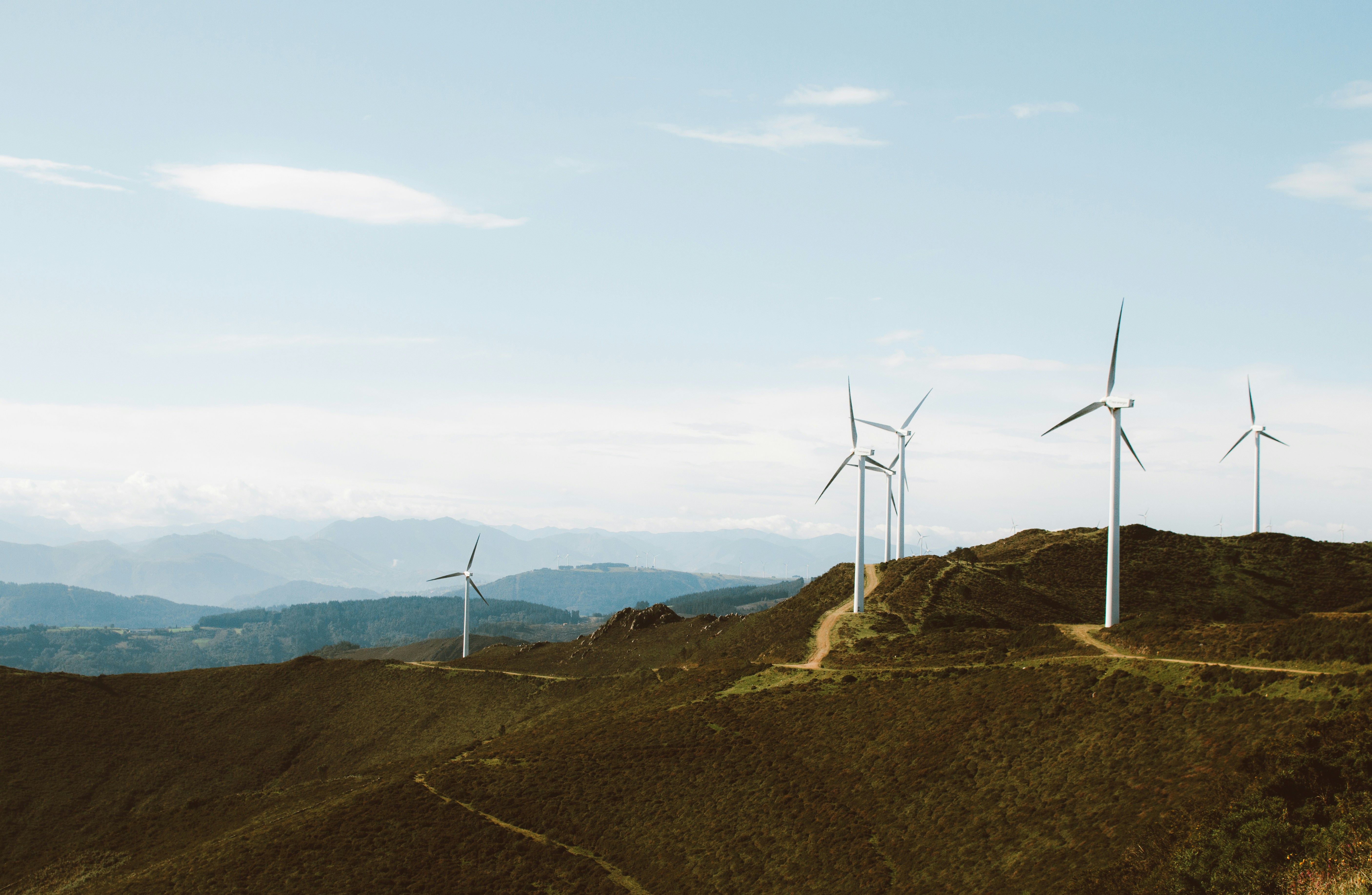 a group of wind turbines on a hill