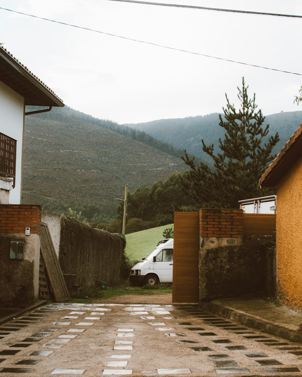 a white van parked in a driveway next to a building