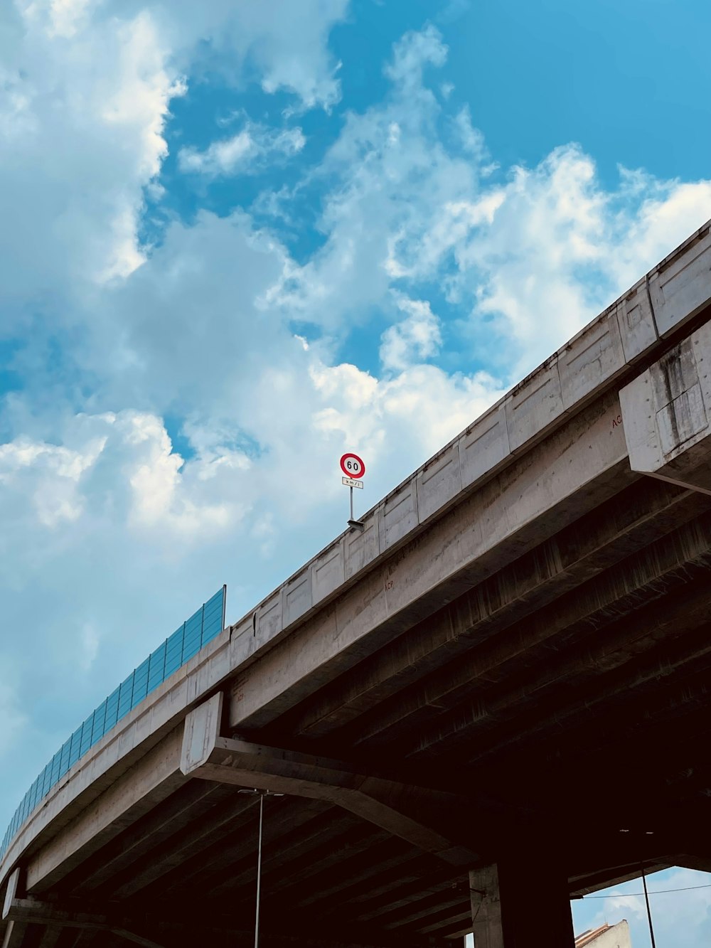 a red stop sign sitting on the side of a bridge