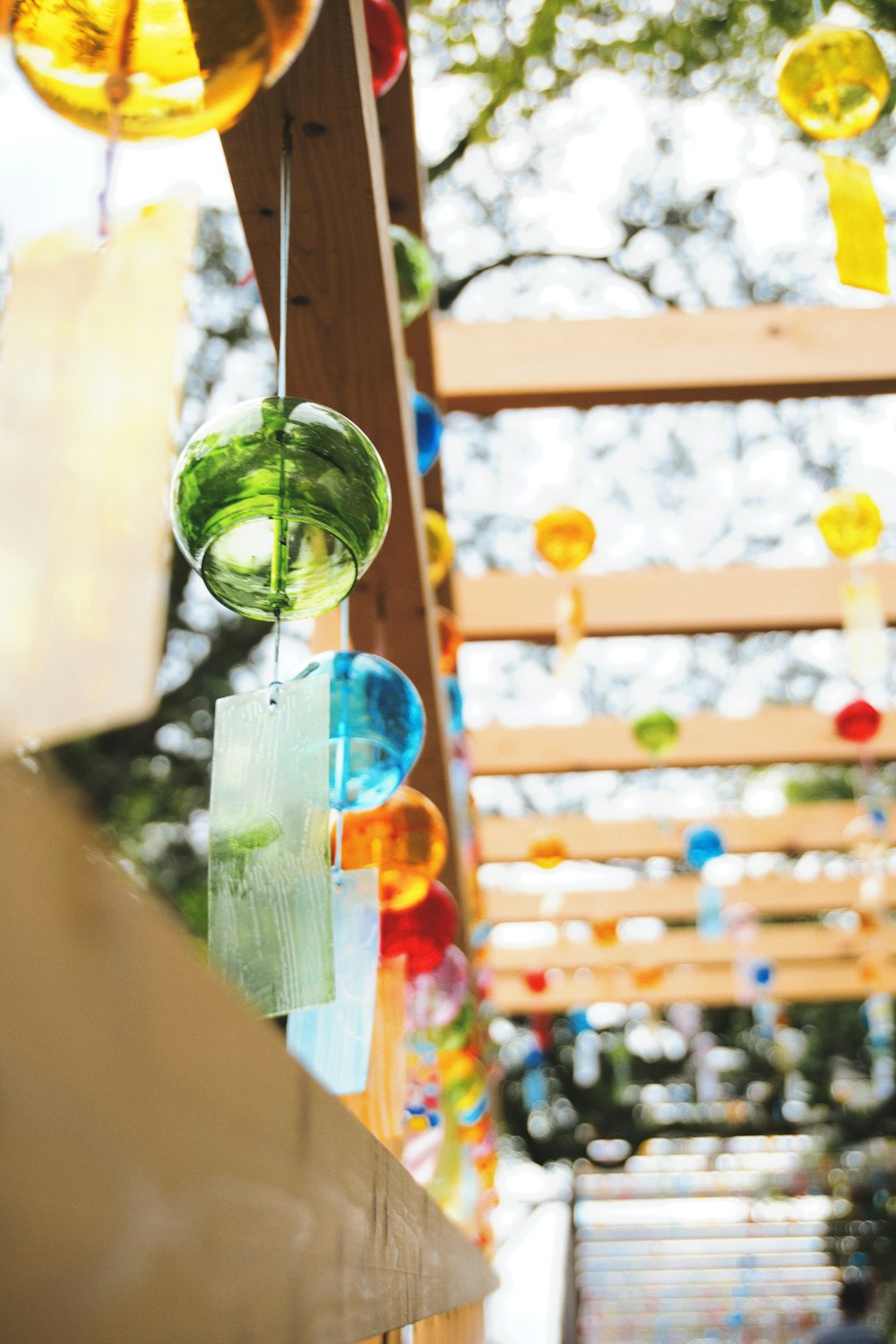 a bunch of glass balls hanging from a wooden structure