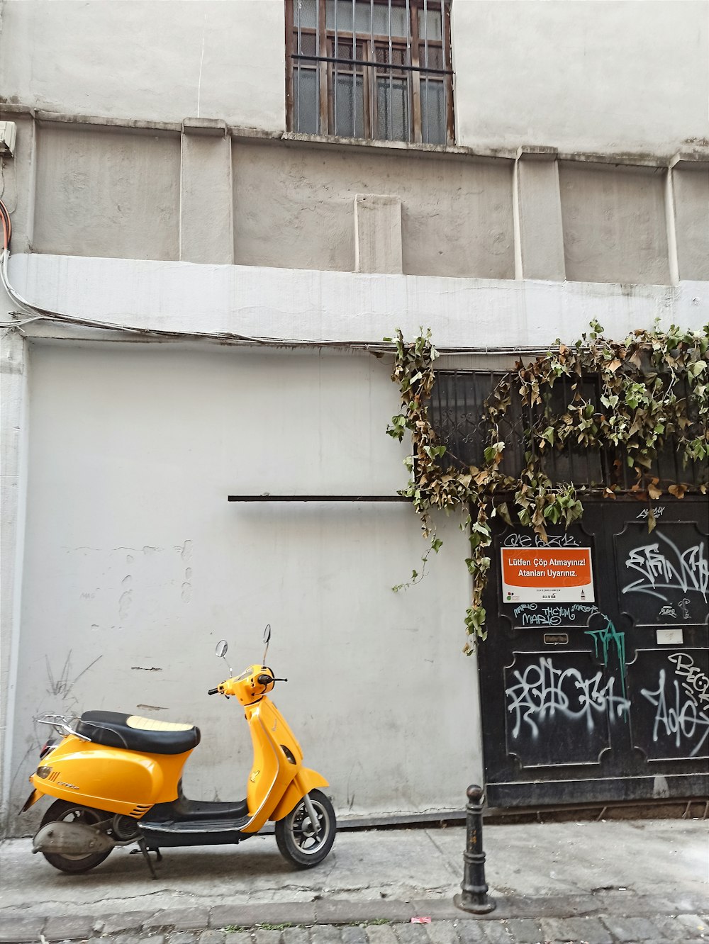 a yellow scooter parked in front of a building