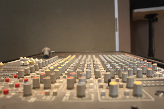 Front view of a professional sound mixing console with colorful knobs and sliders