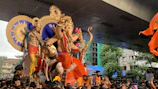 A vibrant procession of devotees carrying decorated idols during festival time.