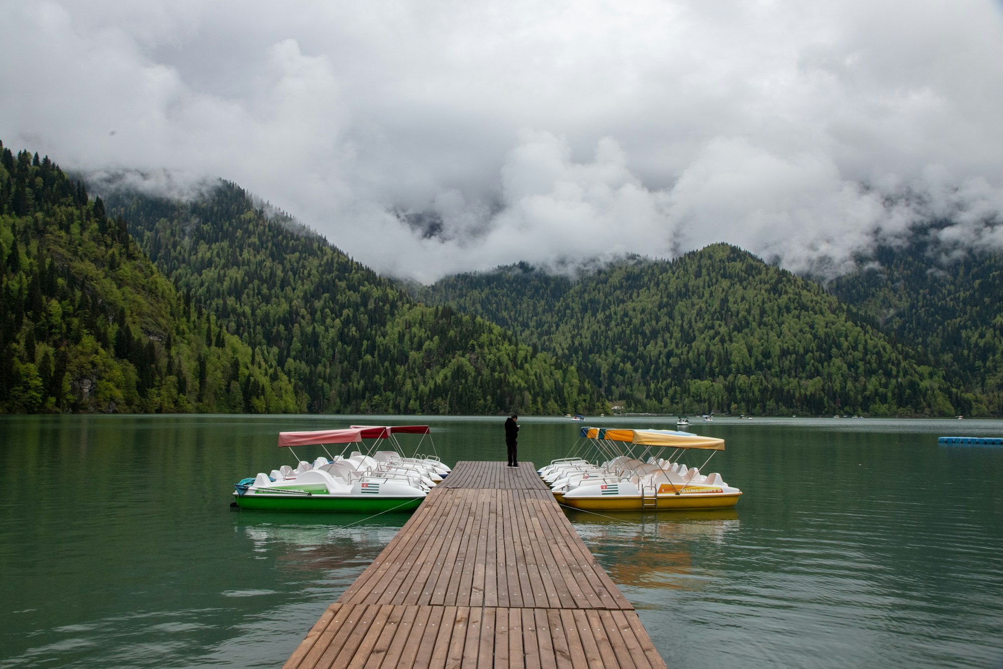 a dock on a lake with several boats in the water