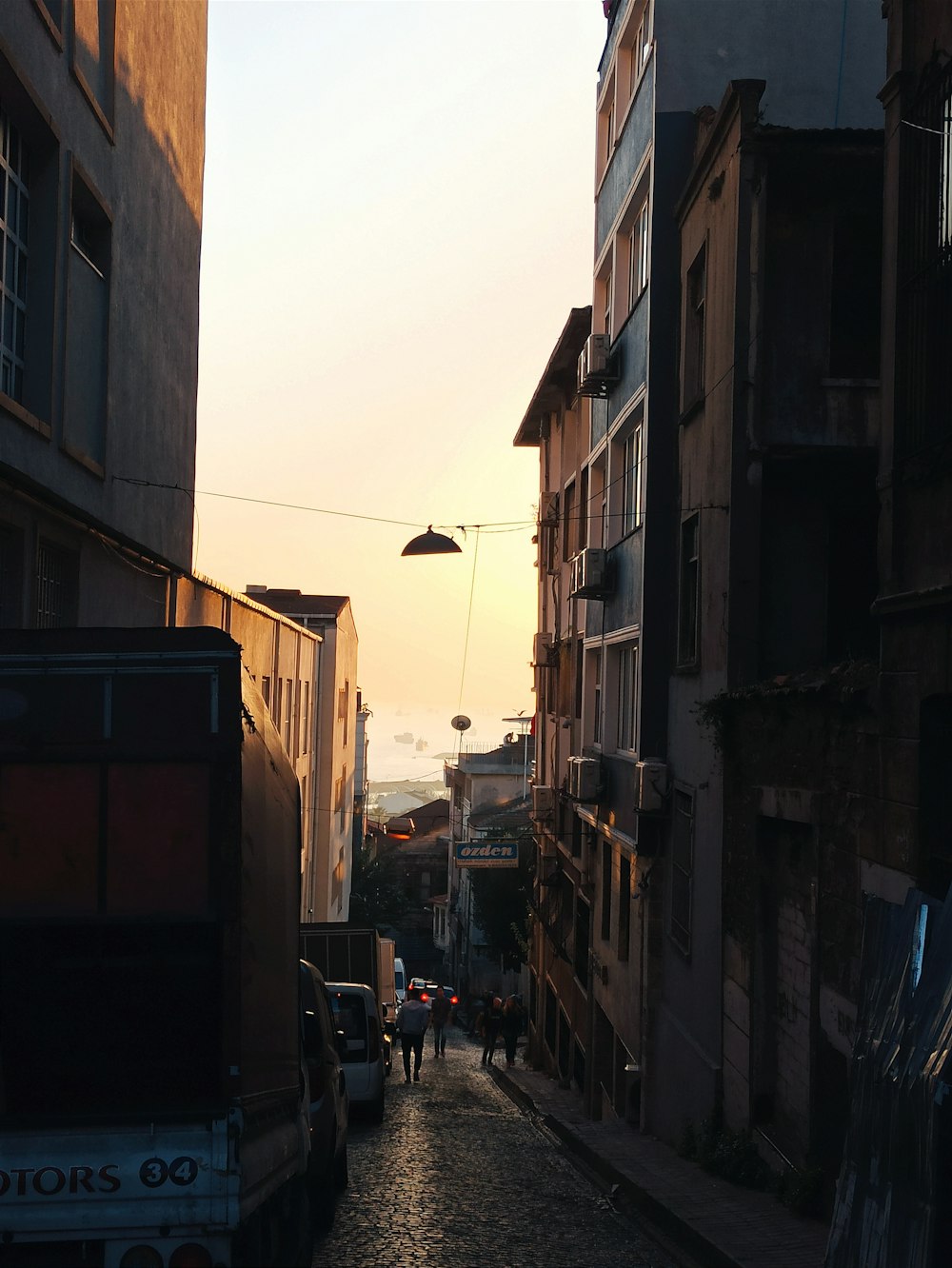 a group of people walking down a street next to tall buildings