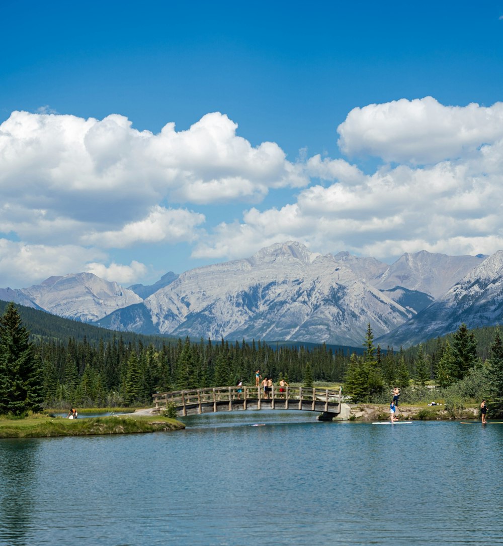 a bridge over a lake with mountains in the background
