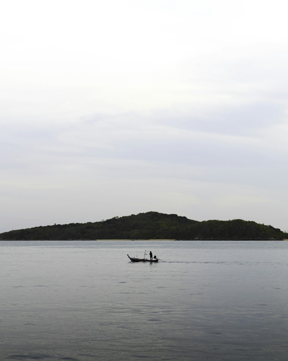 two people in a small boat on a large body of water