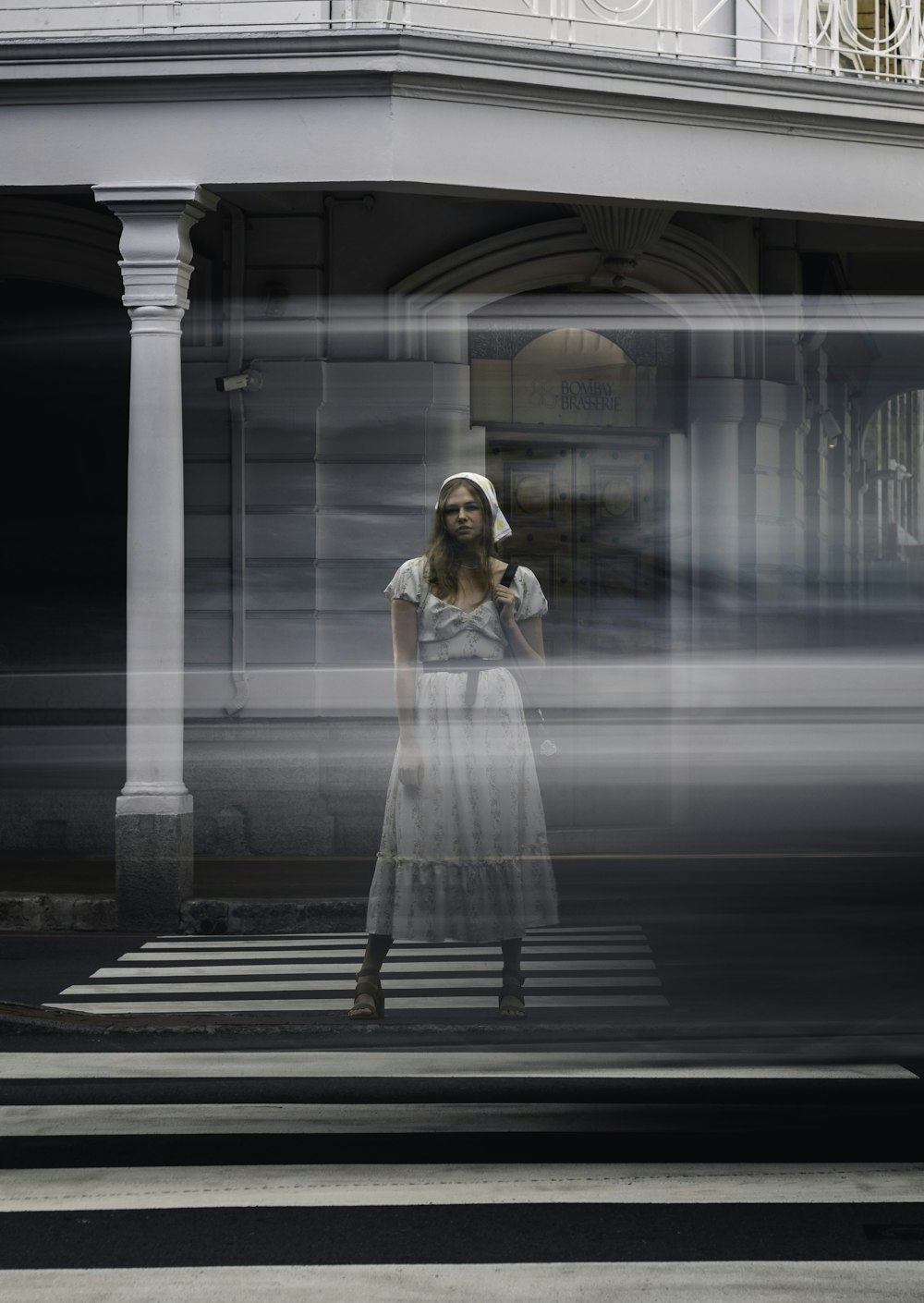 a woman in a white dress standing in front of a building