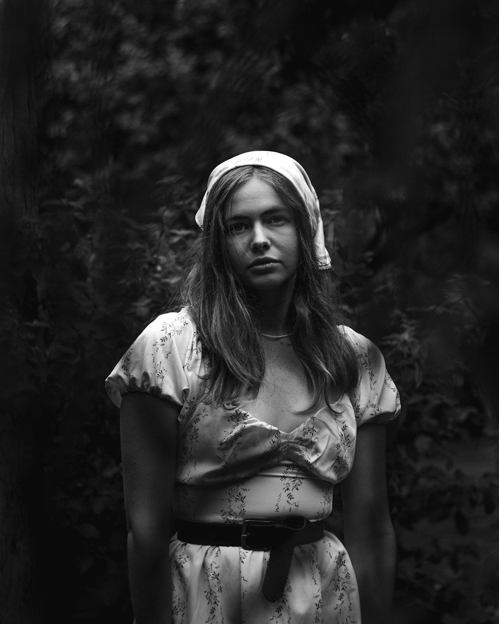 a black and white photo of a woman in a dress