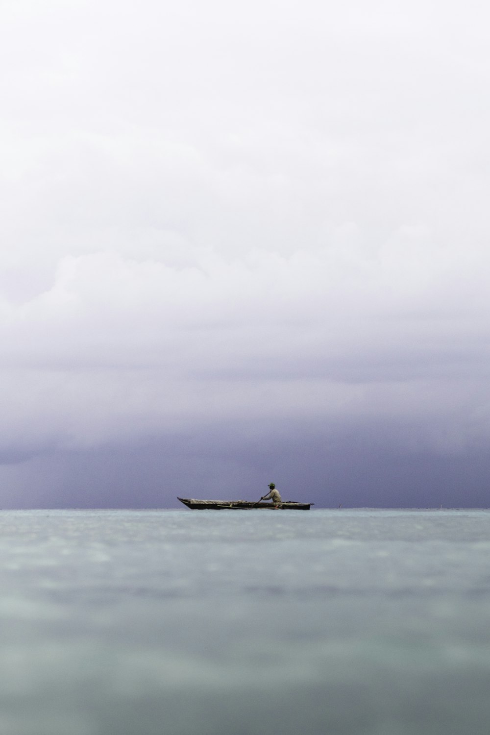 a man in a boat in the middle of the ocean