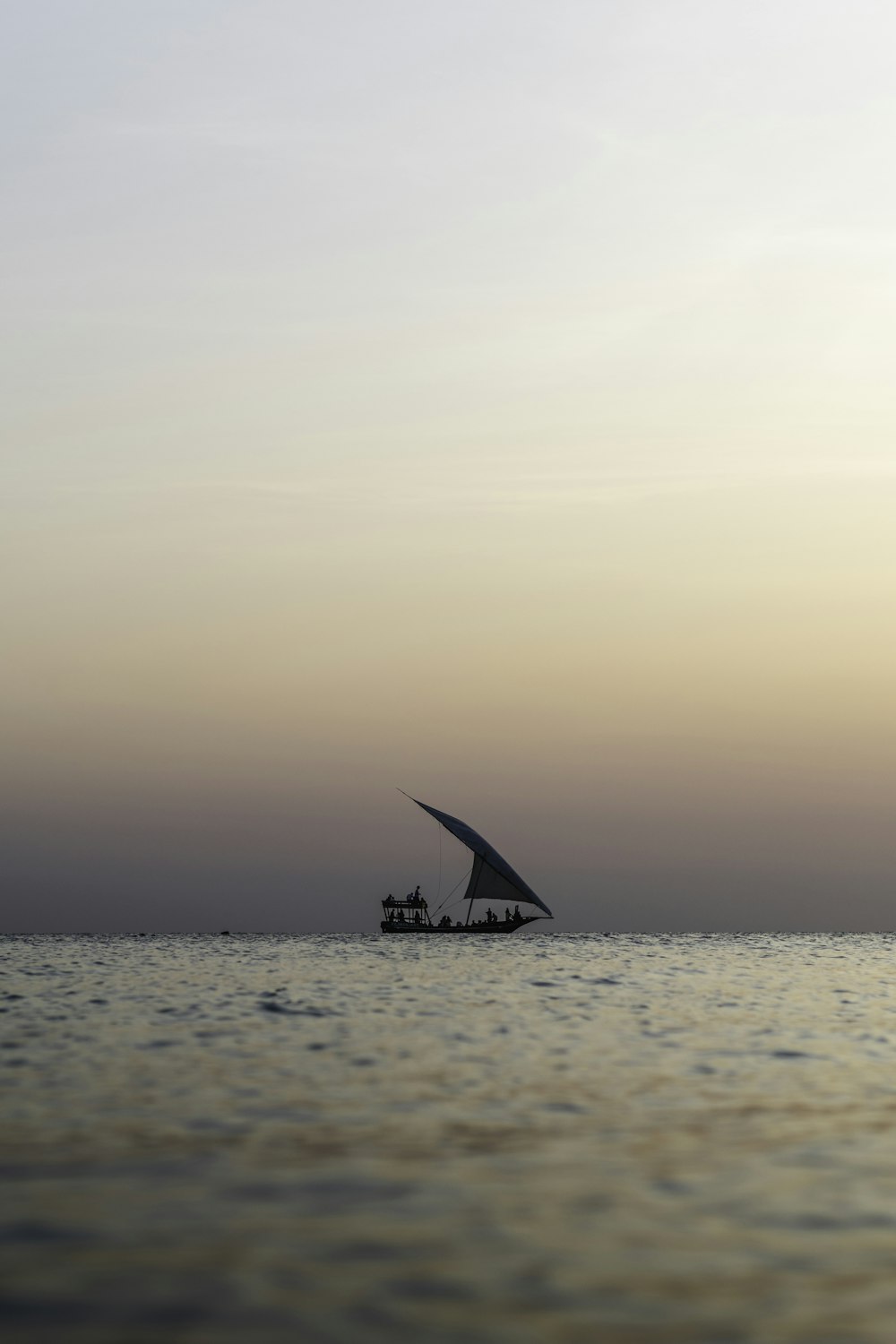 a sail boat in the middle of a body of water