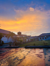 Exterior view of a charming building surrounded by greenery at sunset.