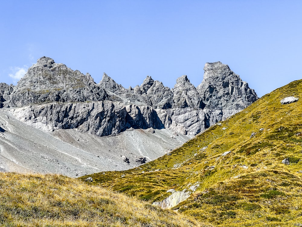 a group of mountains with grass on the side of them