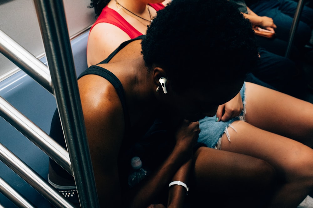 a woman sitting on a bus looking down at her phone