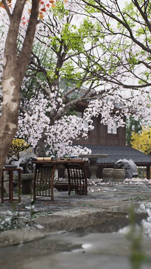 A serene Japanese garden with a tea ceremony setup under cherry blossoms.