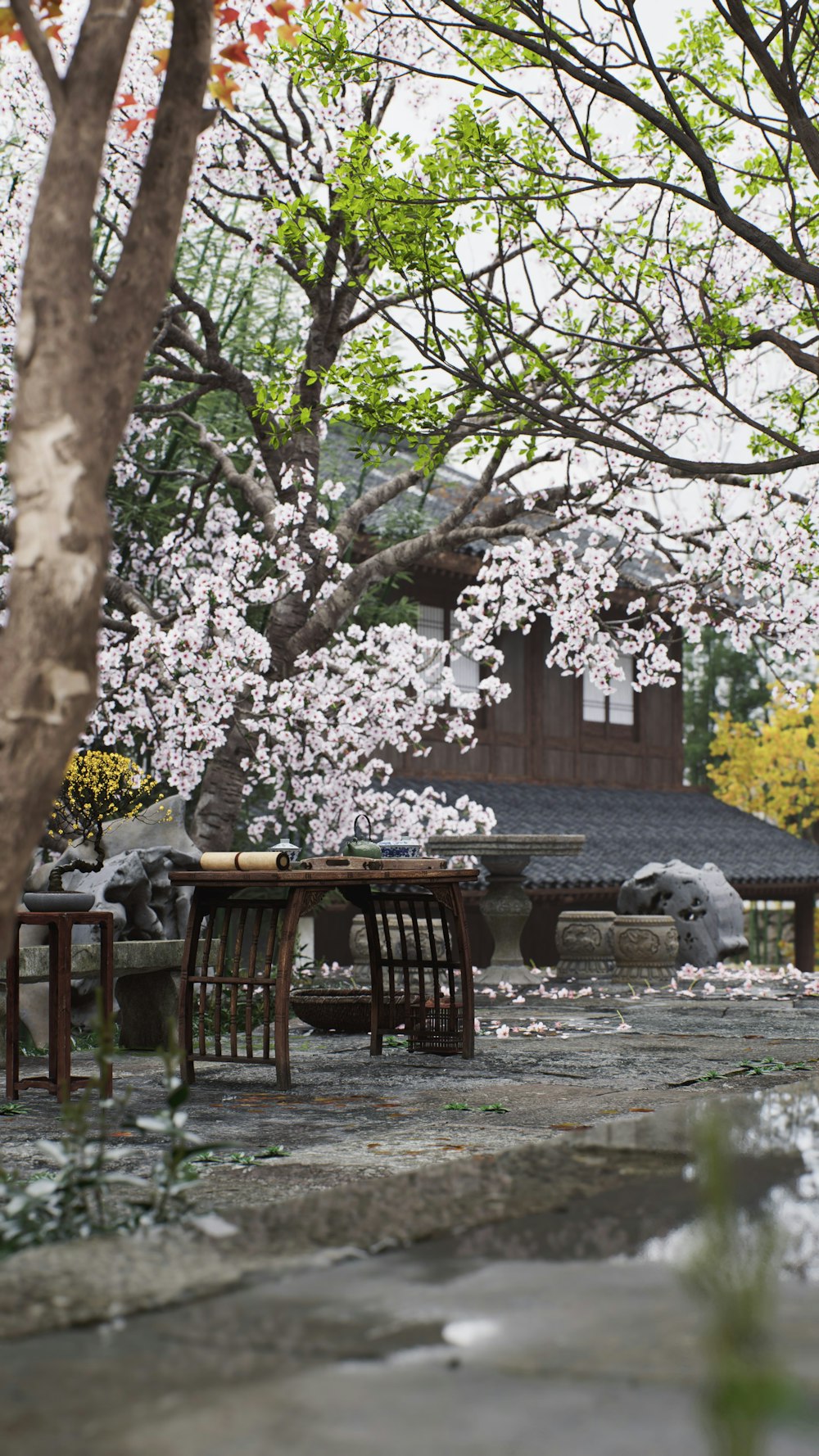 a table and chairs in front of a flowering tree