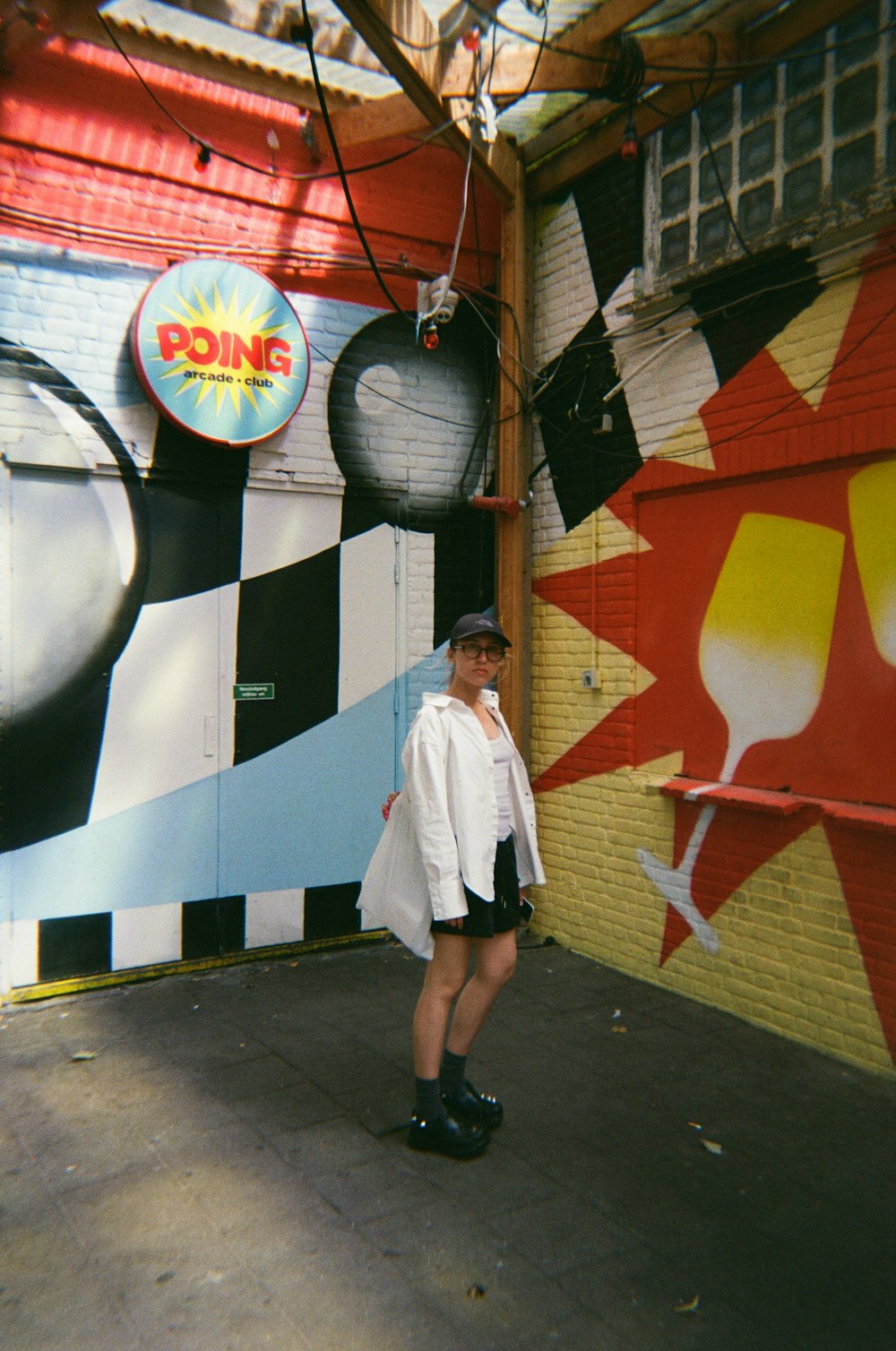 a woman standing in front of a colorful wall