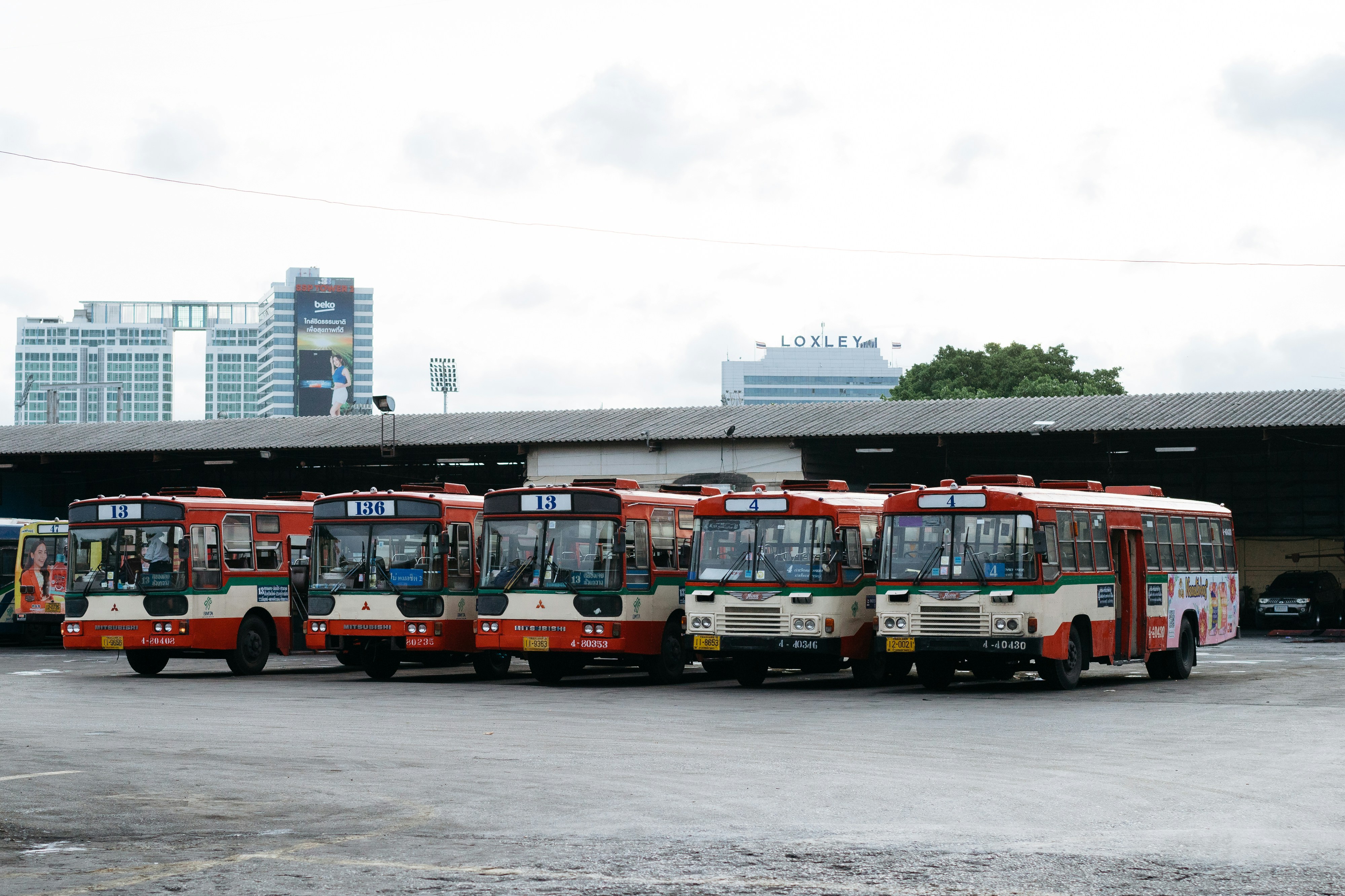 A group of buses parked next to each other in a parking lot photo