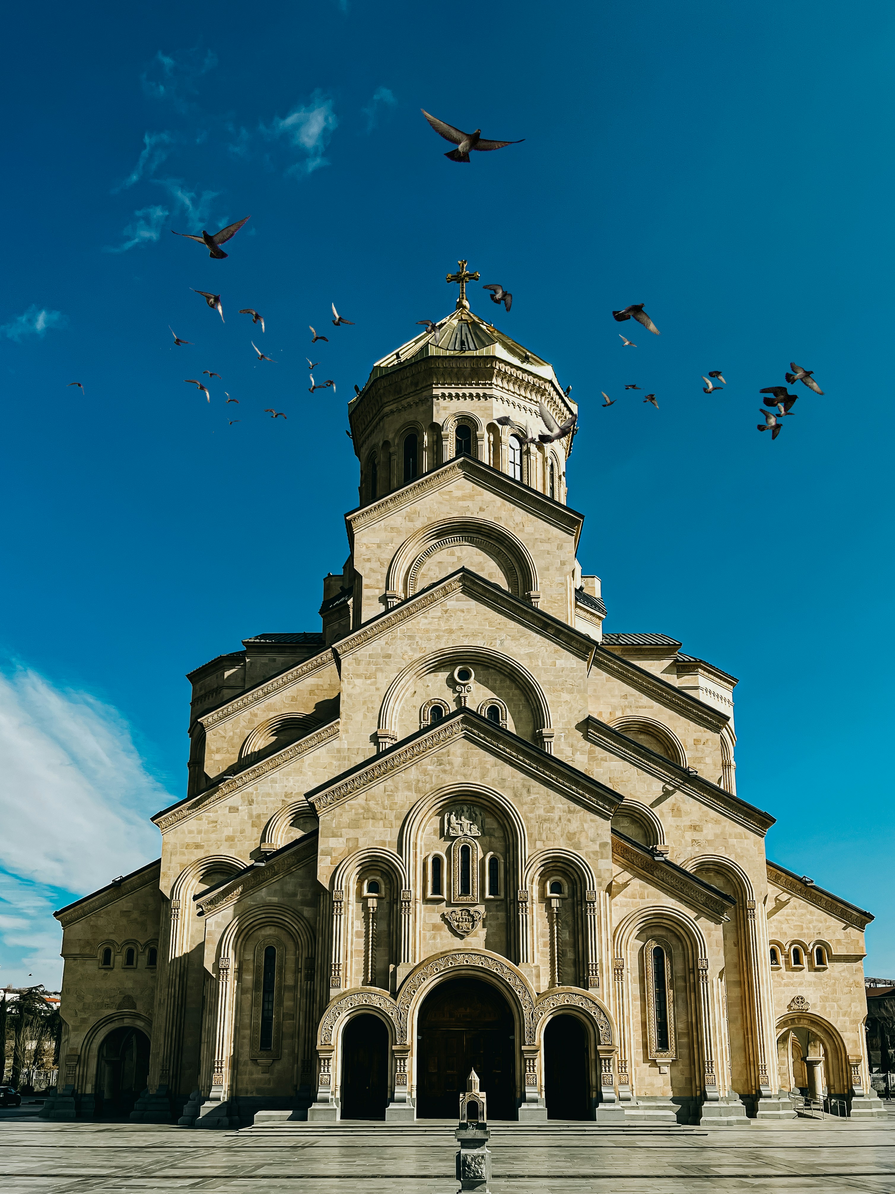 a large church with birds flying around it