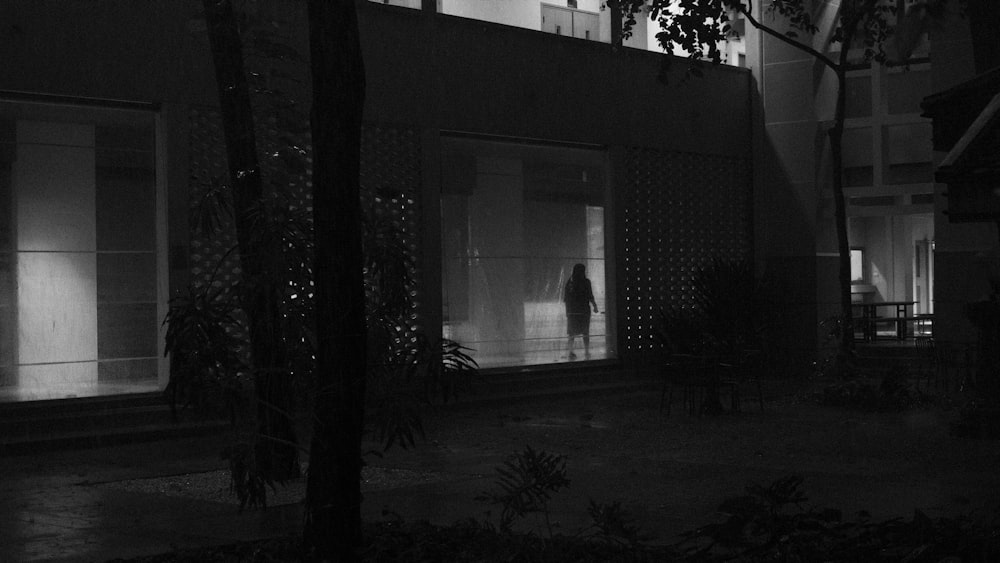 a person standing outside of a building at night