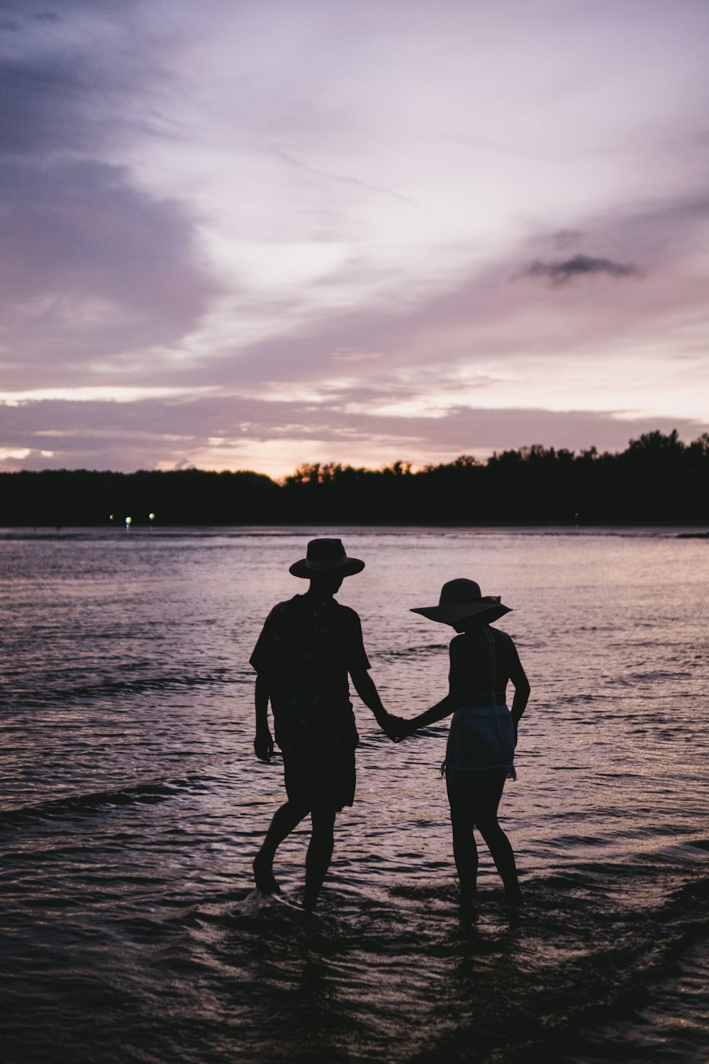 two people standing in the water holding hands